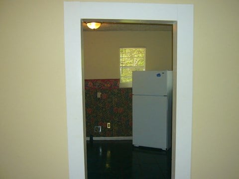 a view of a kitchen from a doorway with a refrigerator