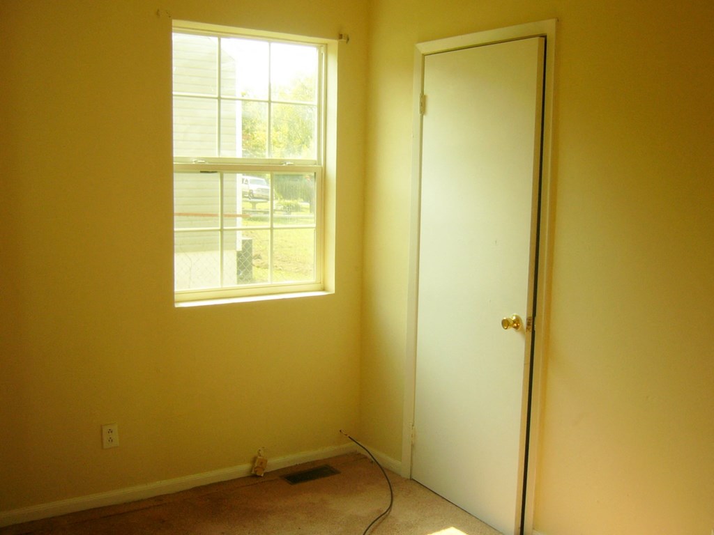 an empty room with a window and a door