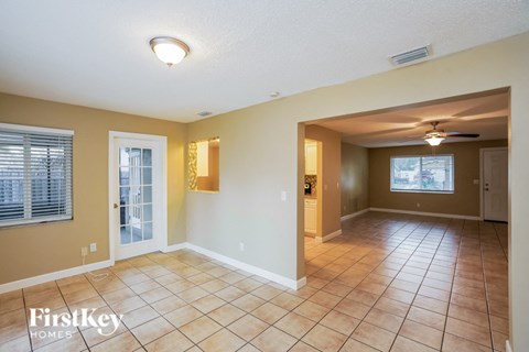 a large living room with tile flooring and a white door