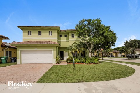 A house with a garage and a driveway in front of it.