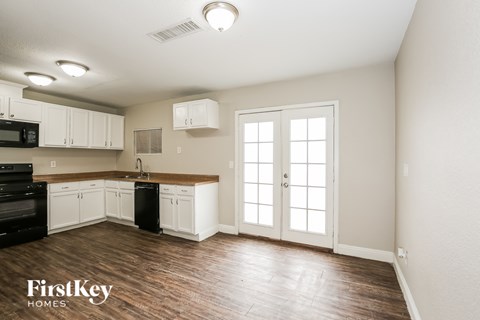 A kitchen with white cabinets and a black oven.