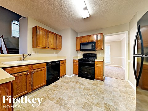 A kitchen with wooden cabinets and black appliances.