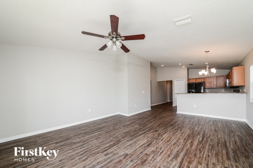 A room with a ceiling fan and wooden flooring.