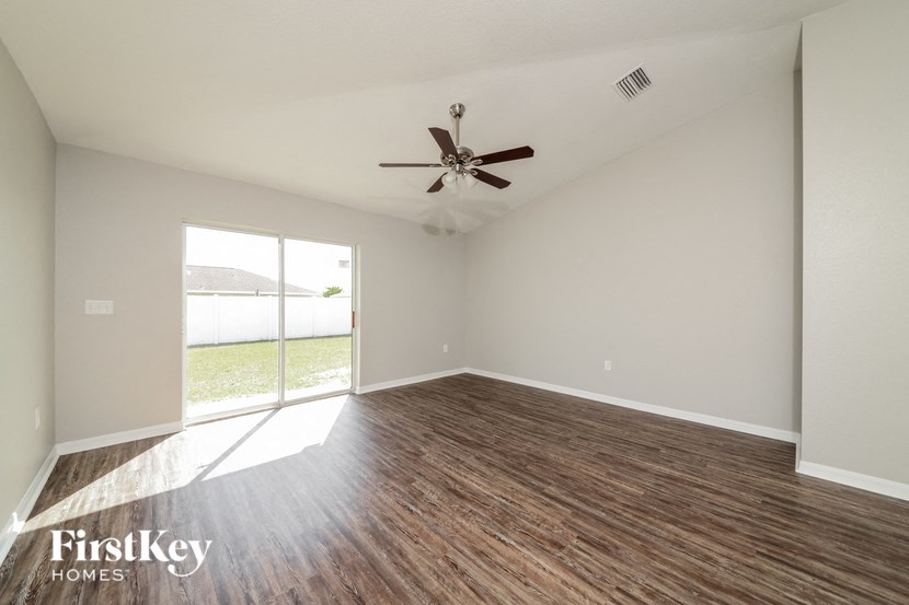 A room with a ceiling fan and wooden flooring.