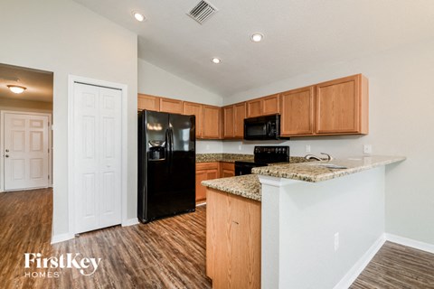 A kitchen with wooden cabinets and a granite countertop.