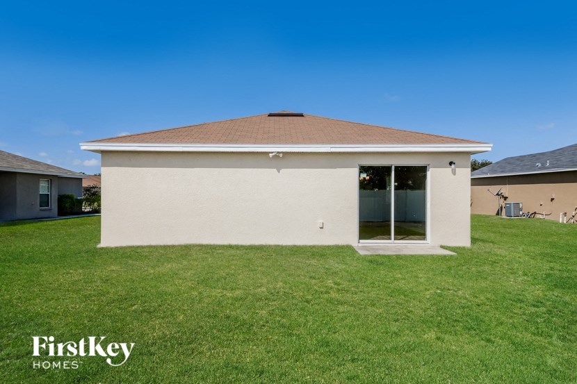 A house with a brown roof and a white exterior is for sale by FirstKey Homes.