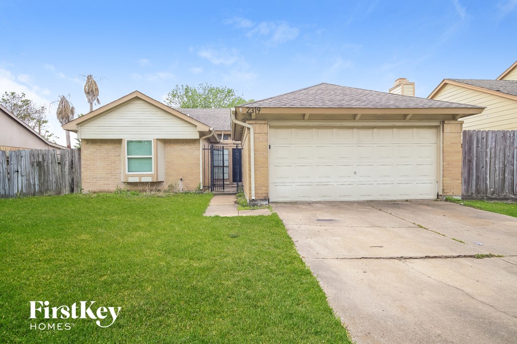 a home with a driveway and a white garage door