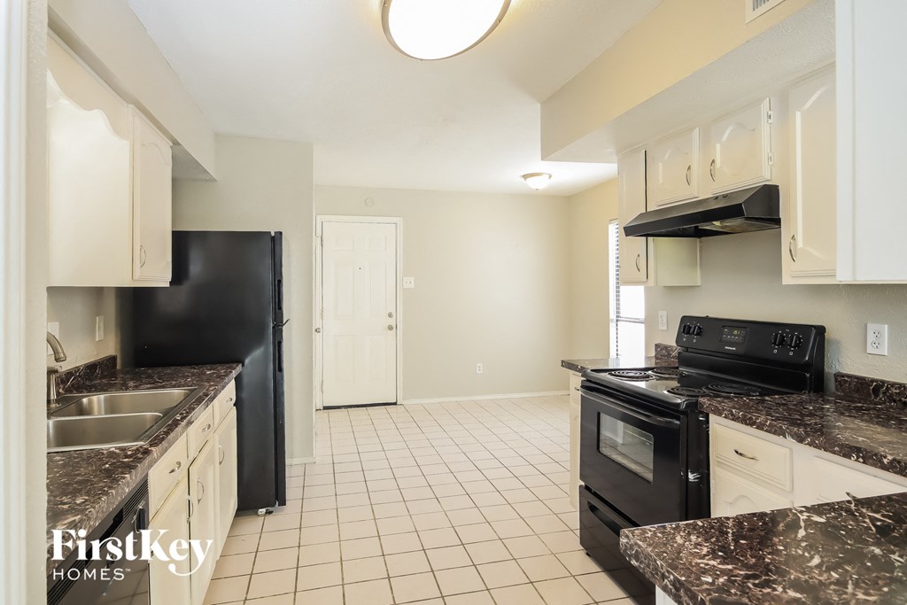 a kitchen with granite counter tops and black appliances