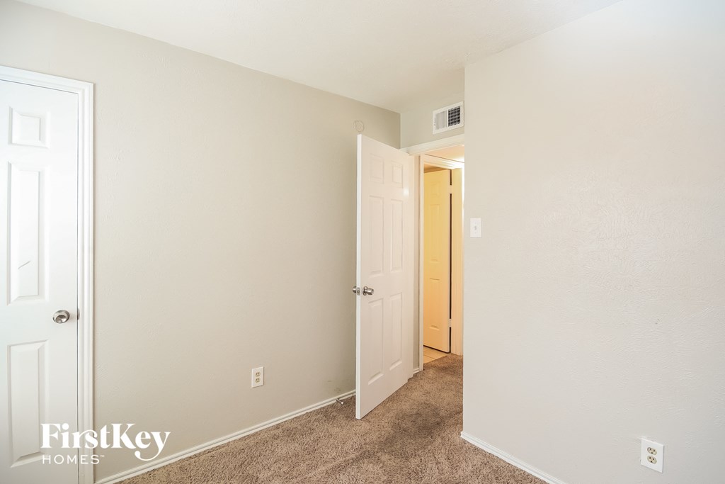 a bedroom with an open door and a hallway to a closet