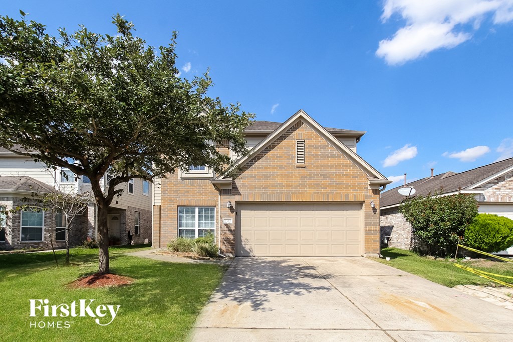 a house with a garage door and a tree