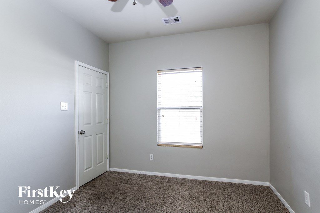 a bedroom with white walls and a window and a white door
