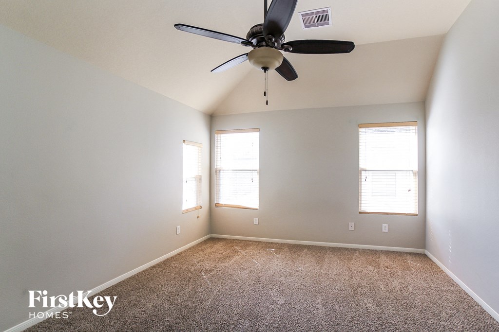 a bedroom with a ceiling fan and a carpeted floor