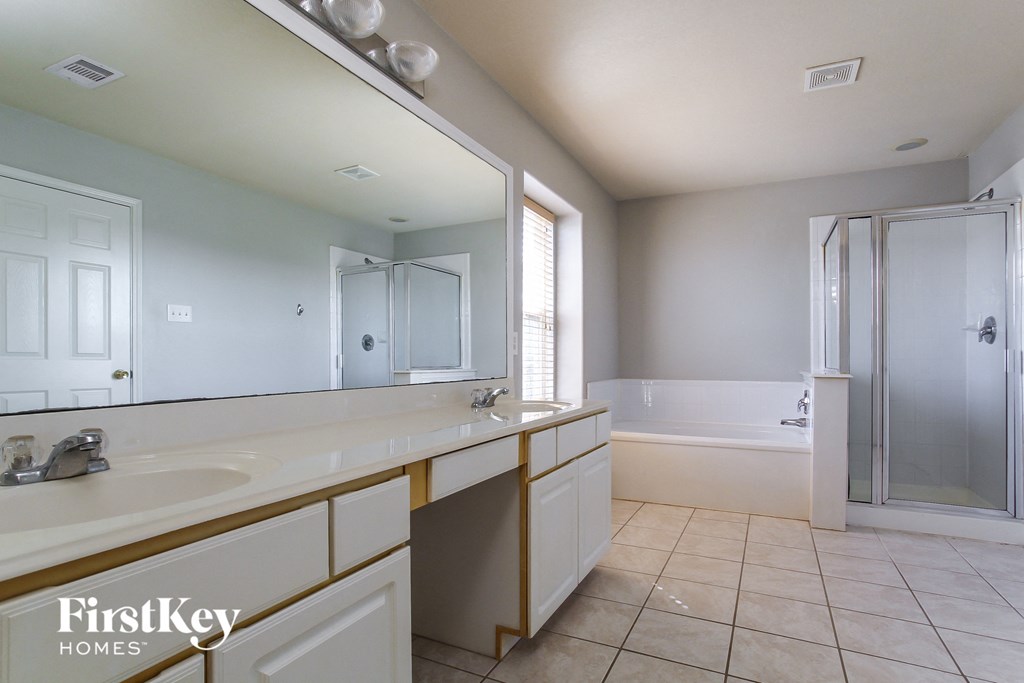 a bathroom with a large mirror and a sink and a shower