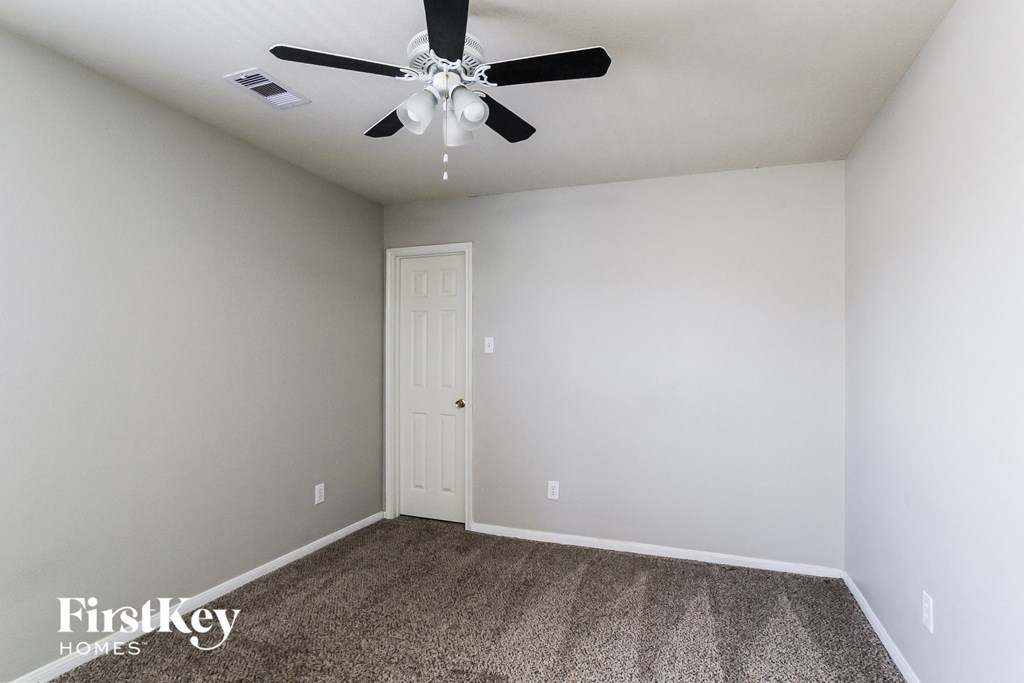 a room with carpet and a ceiling fan