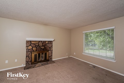 a living room with a fireplace and a large window