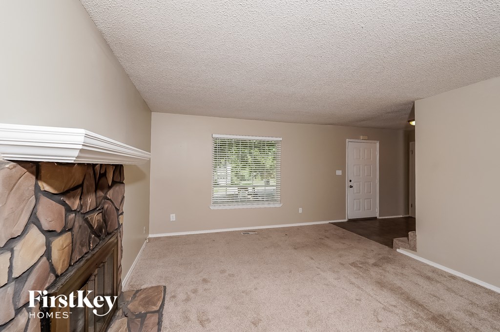 a living room with a fireplace and a carpeted floor