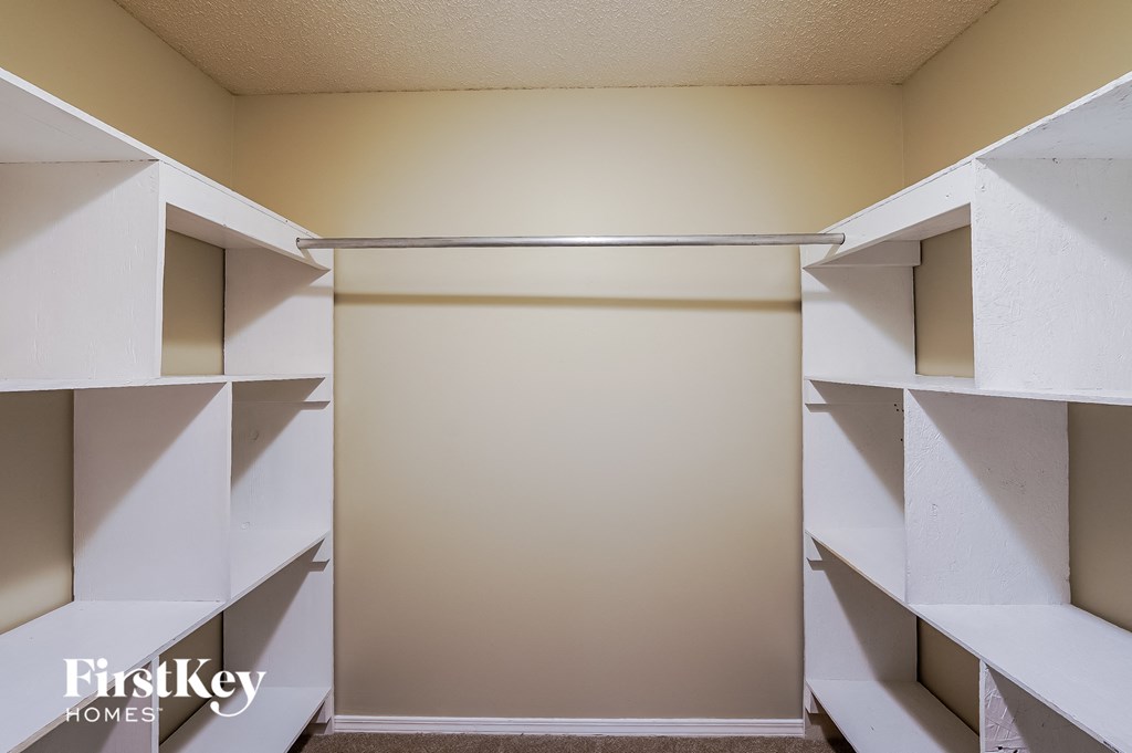 a walk in closet with shelves and a sliding closet door