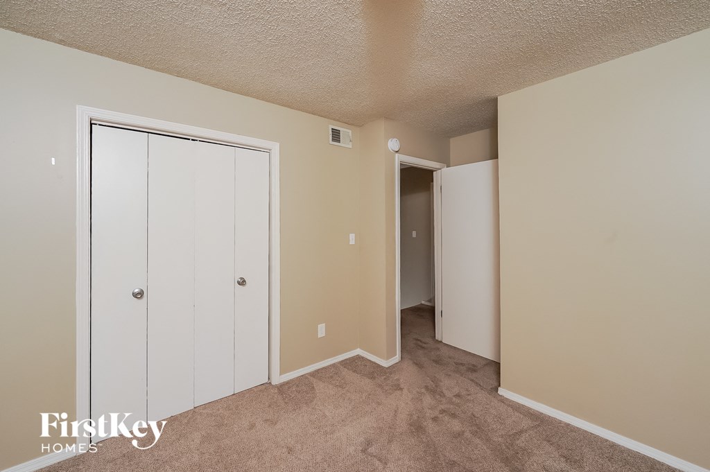a bedroom with two closets and a door to a hallway