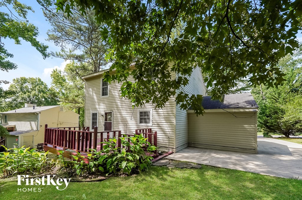 a white house with a yard and a red fence