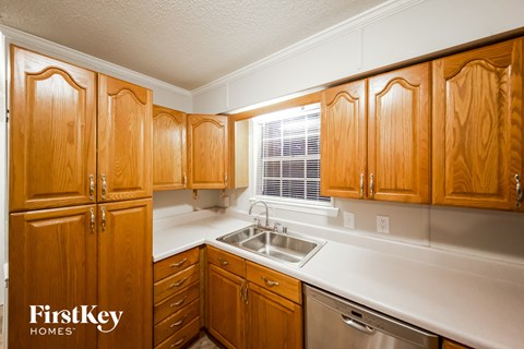 A kitchen with wooden cabinets and a stainless steel sink.