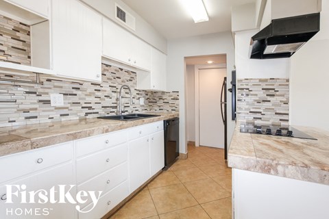a white kitchen with marble counter tops and white cabinets