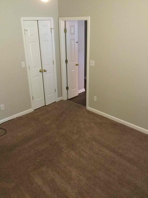 a room with a carpeted floor and two doors