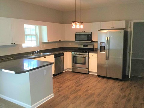 a kitchen with stainless steel appliances and a wooden floor