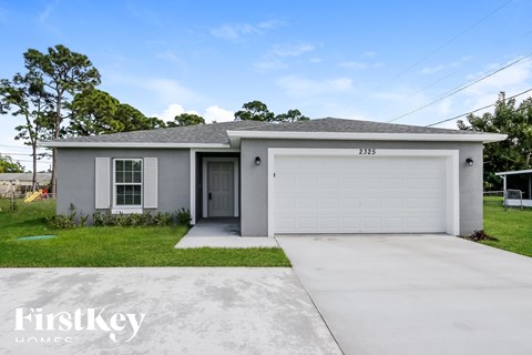 A grey house with a white garage door and a black door.