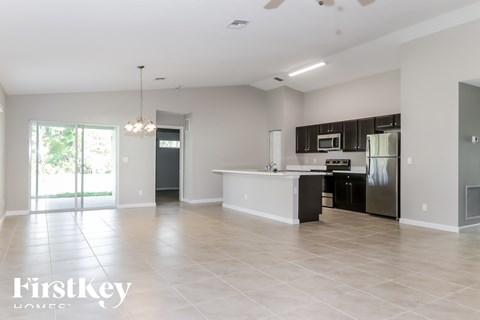 A spacious kitchen with a refrigerator, microwave, and oven.