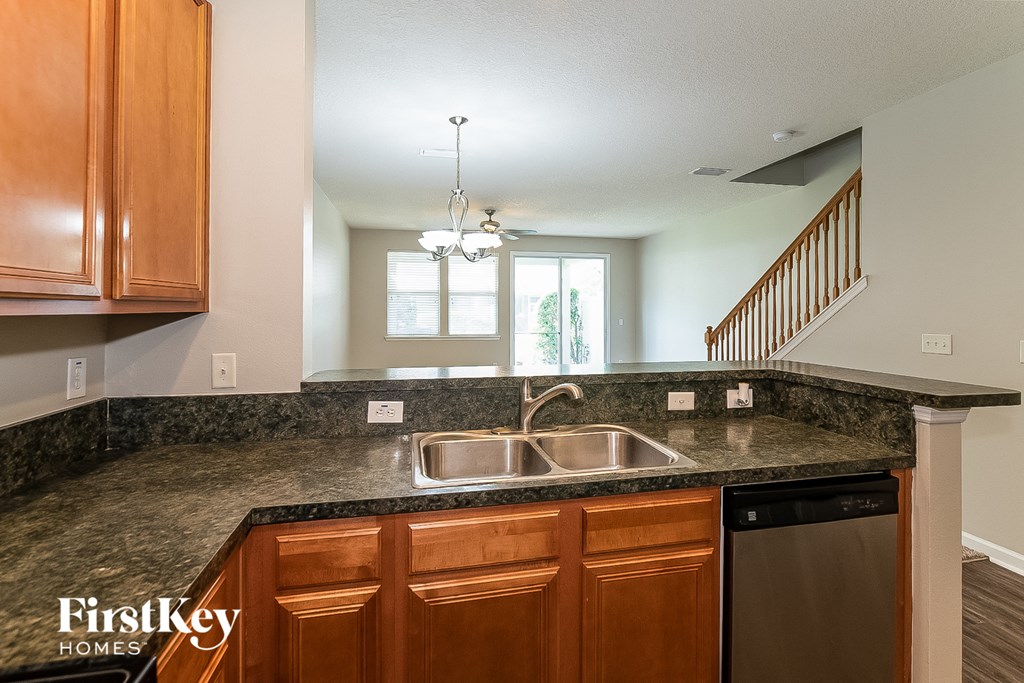 A kitchen with wooden cabinets and a granite countertop.