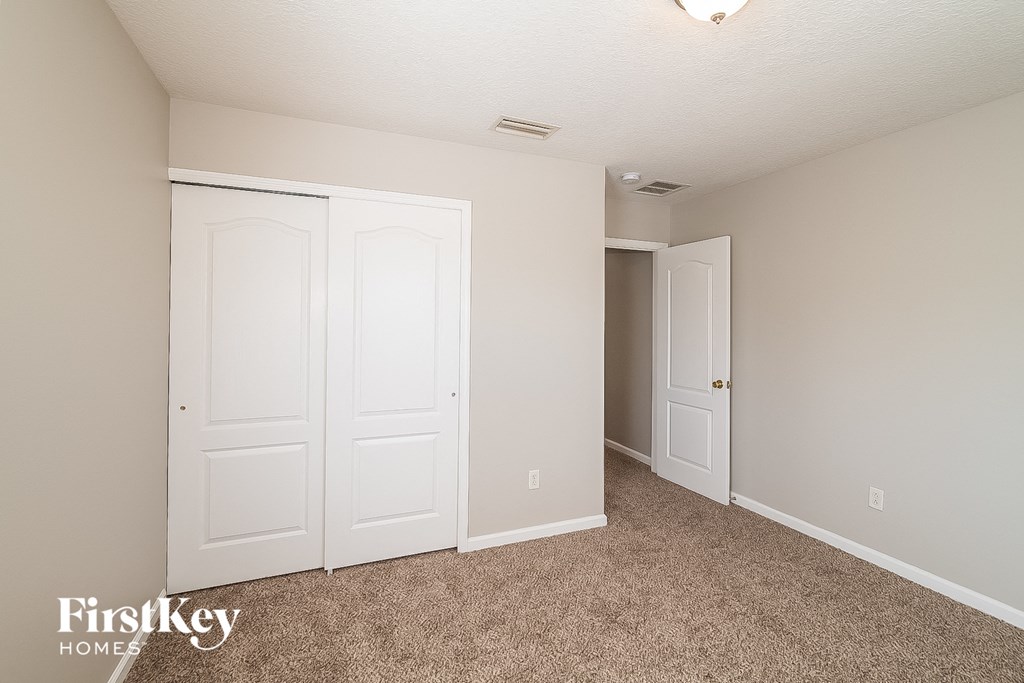 A room with two doors and a carpeted floor.