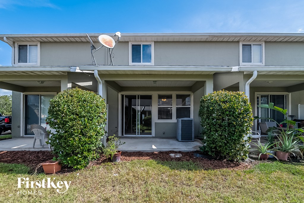 A modern house with a large front yard and a satellite dish on the roof.