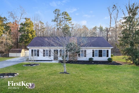 a white house with a tree in the front yard