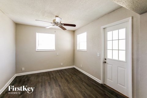 an empty room with a ceiling fan and a white door