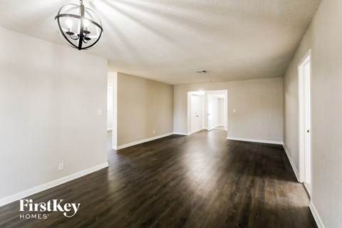 an empty living room with white walls and wood floors