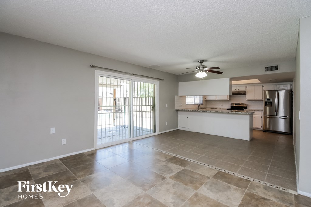 A spacious kitchen and living room with a sliding glass door leading to a balcony.