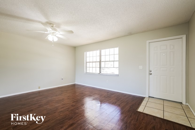 A room with a wooden floor and a ceiling fan.