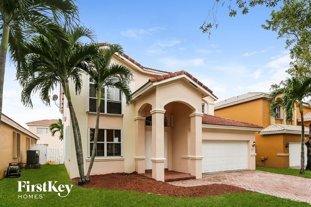 A house with a palm tree in front of it.