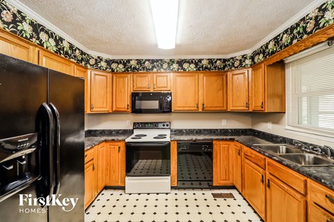 a kitchen with black appliances and wooden cabinets
