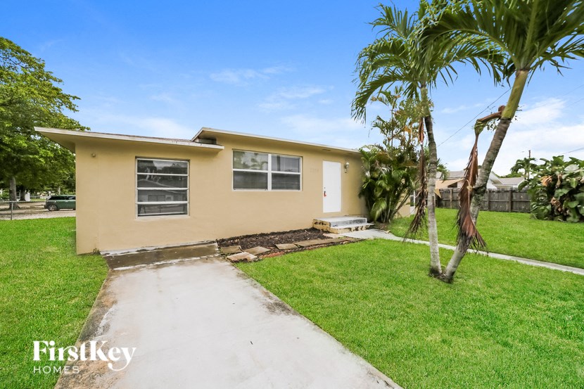 a beige house with a palm tree in the yard