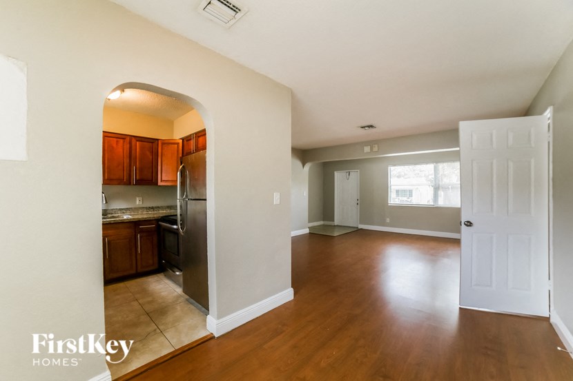 an empty kitchen and living room with wood floors and white walls
