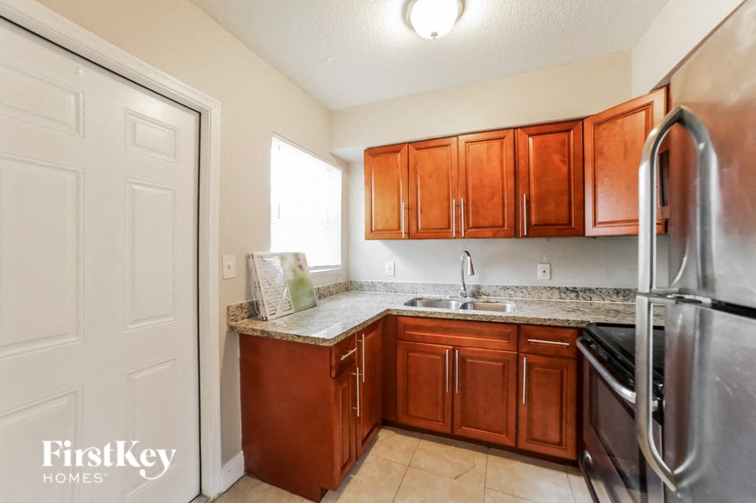a kitchen with wooden cabinets and a stainless steel refrigerator
