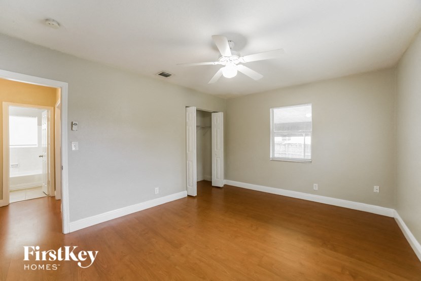 an empty living room with wood flooring and a ceiling fan