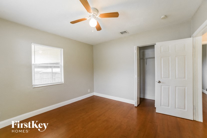 a living room with wood floors and a ceiling fan
