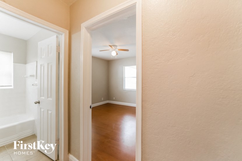 an empty room with a white door and a ceiling fan