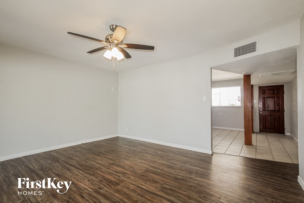 the living room of an empty house with a ceiling fan