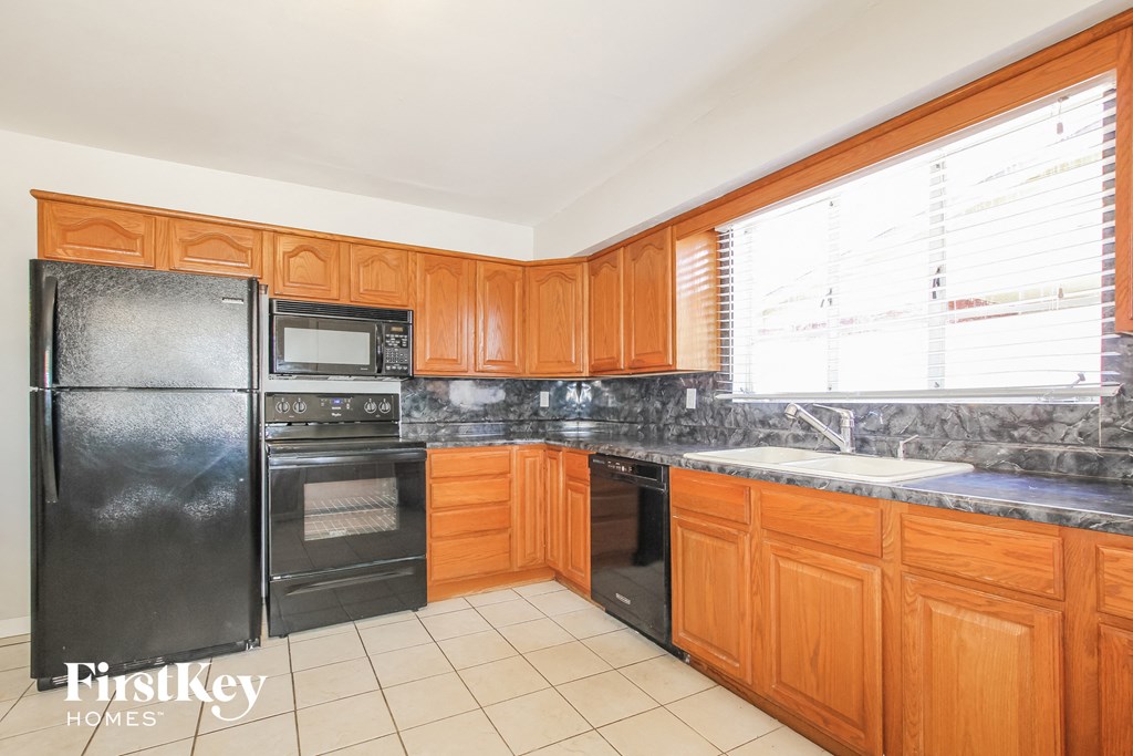 a kitchen with black appliances and wooden cabinets