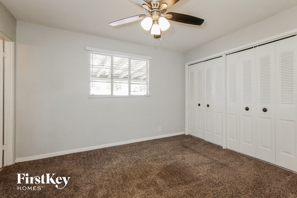 a bedroom with two closets and a ceiling fan