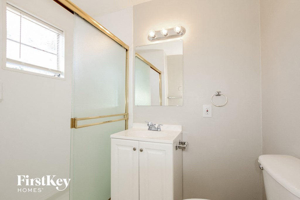 a white bathroom with a mirror and a toilet and a sink