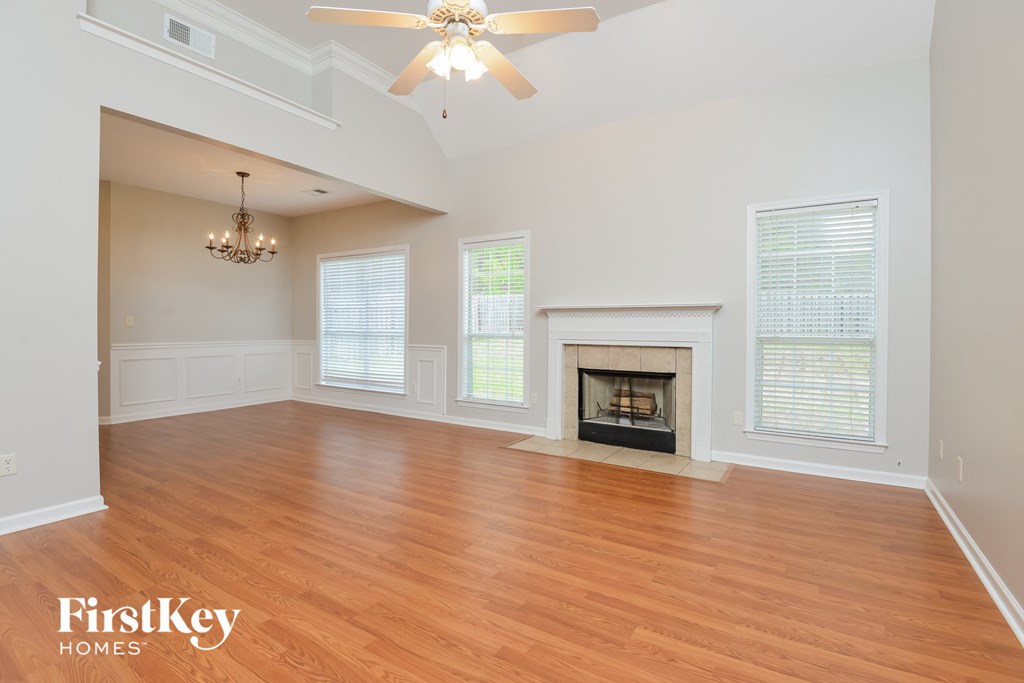 A spacious living room with a fireplace and a chandelier.